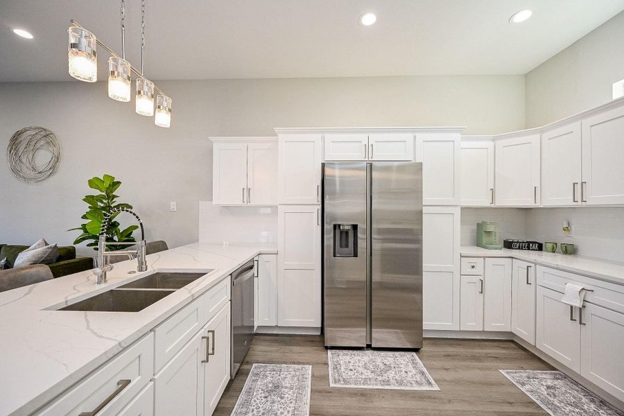 Open kitchen with pristine quartz countertops.