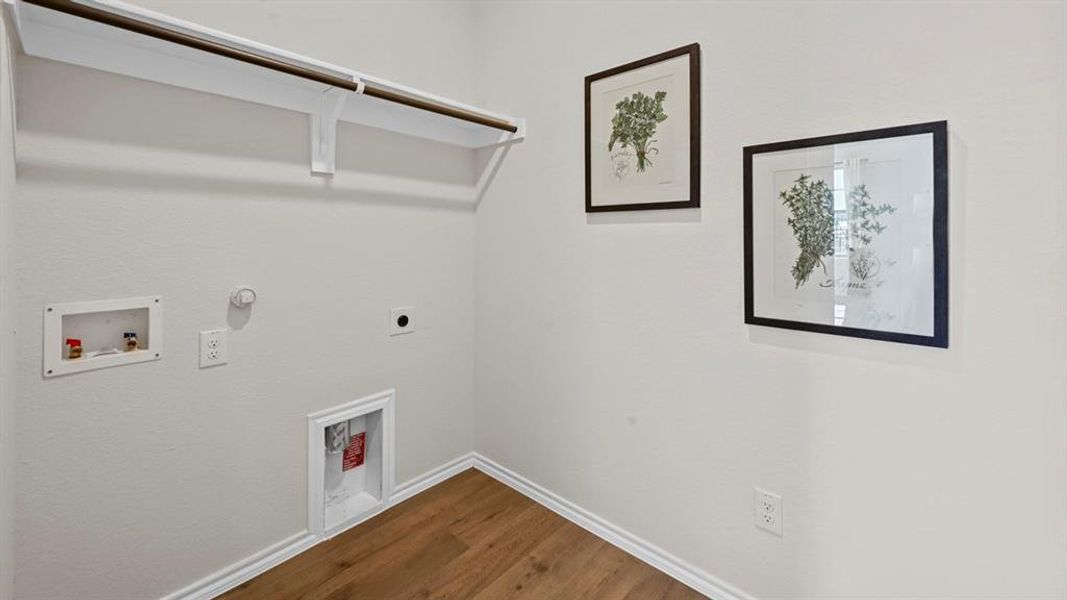Utility room featuring wood-style flooring and a built-in shelf with a hanging rod Utility room featuring wood-style flooring and a built-in shelf with a hanging rod