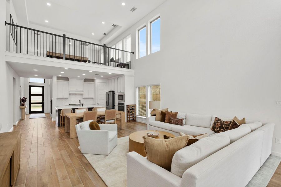 Stunning view from the living room looking back toward the kitchen and the upstairs game room balcony with iron railing. Stunning view from the living room looking back toward the kitchen and the upstairs game room balcony with iron railing.