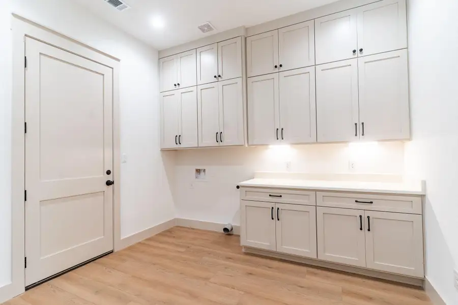 Washroom featuring cabinet space, light wood finished floors, and washer hookup Washroom featuring cabinet space, light wood finished floors, and washer hookup