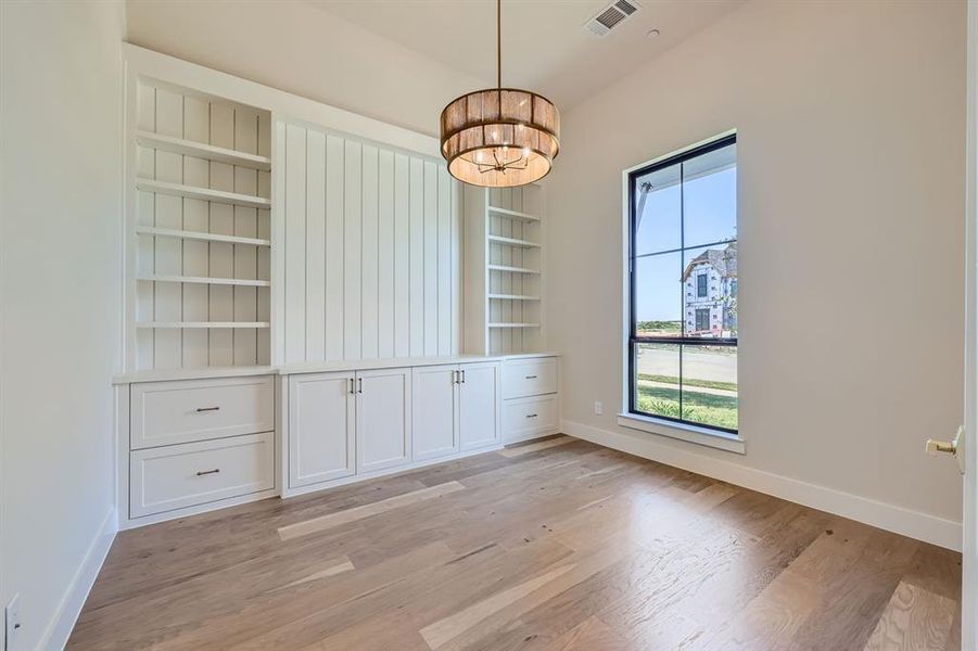 Unfurnished dining area featuring a chandelier and light hardwood / wood-style floors