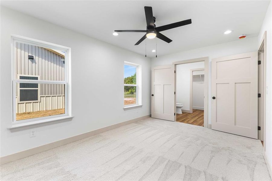 Unfurnished bedroom with carpet, recessed lighting, a ceiling fan, and ensuite bath Unfurnished bedroom with carpet, recessed lighting, a ceiling fan, and ensuite bath