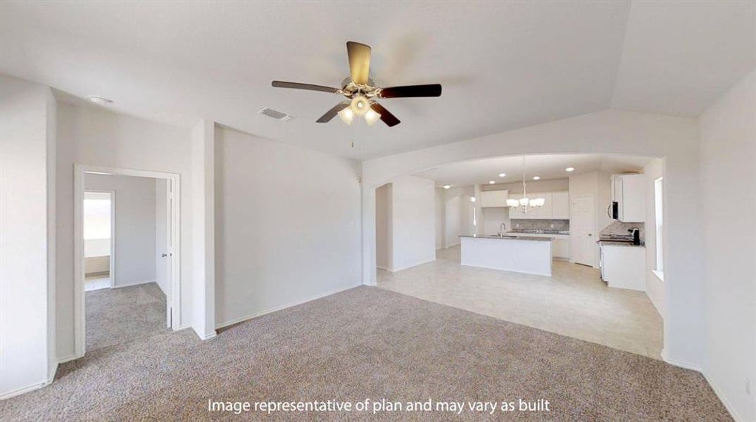 Spacious living area featuring neutral carpeting and a ceiling fan with light fixture Spacious living area featuring neutral carpeting and a ceiling fan with light fixture