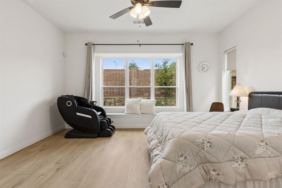 Light wood-finish flooring throughout, featuring a broad window with a built-in window seat