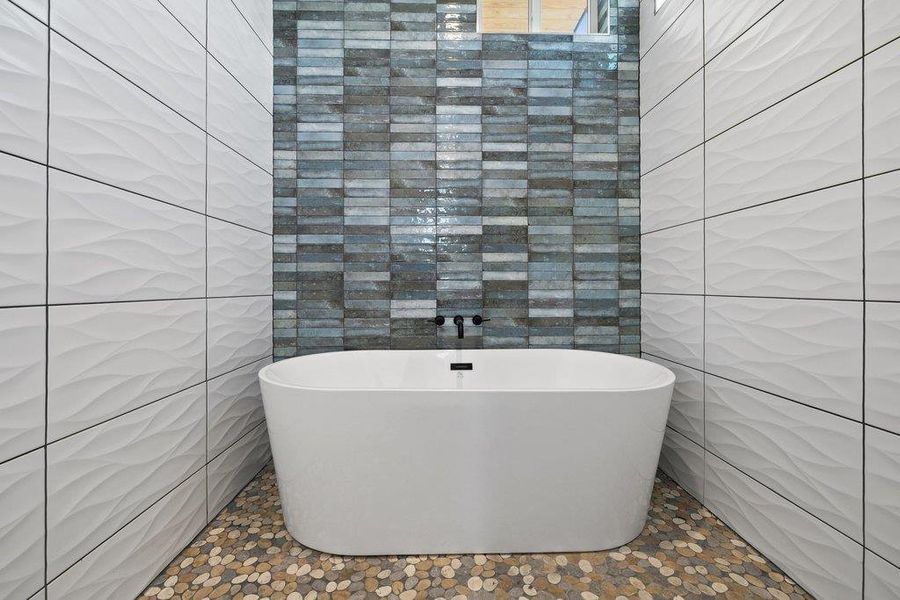 Full bathroom featuring tile walls and a freestanding tub