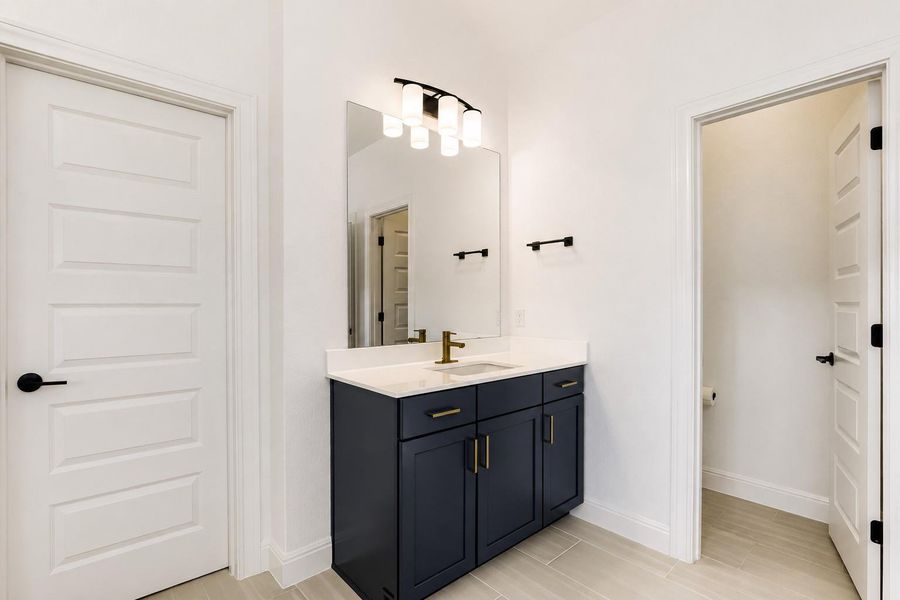 A well-appointed vanity with a modern sink and sleek fixtures offers both style and utility in this bathroom. A well-appointed vanity with a modern sink and sleek fixtures offers both style and utility in this bathroom.