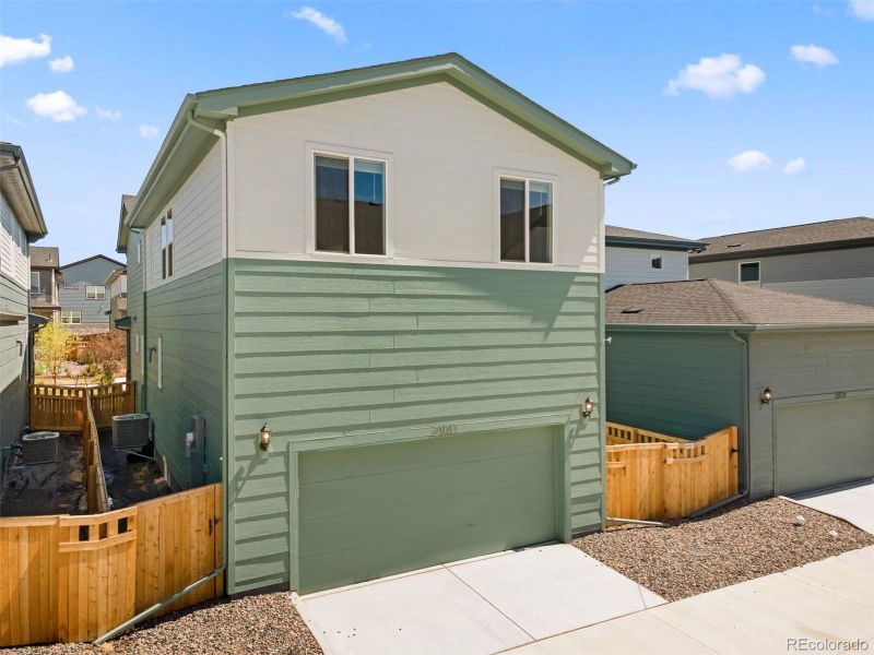Front exterior of a new home in Woodrose at Painted Prairie, Aurora, CO, highlighting curb appeal (Image 21).