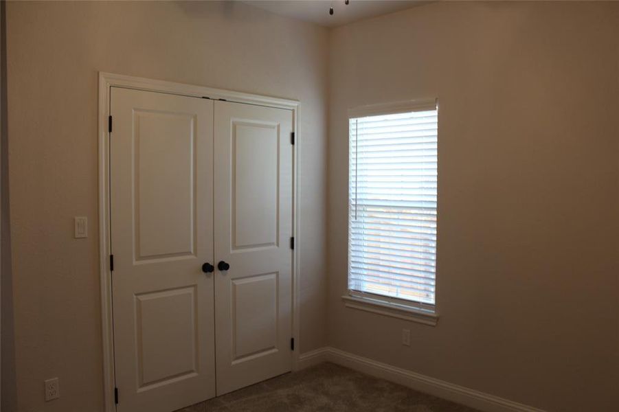 Unfurnished bedroom with carpet floors, a closet, and baseboards Unfurnished bedroom with carpet floors, a closet, and baseboards
