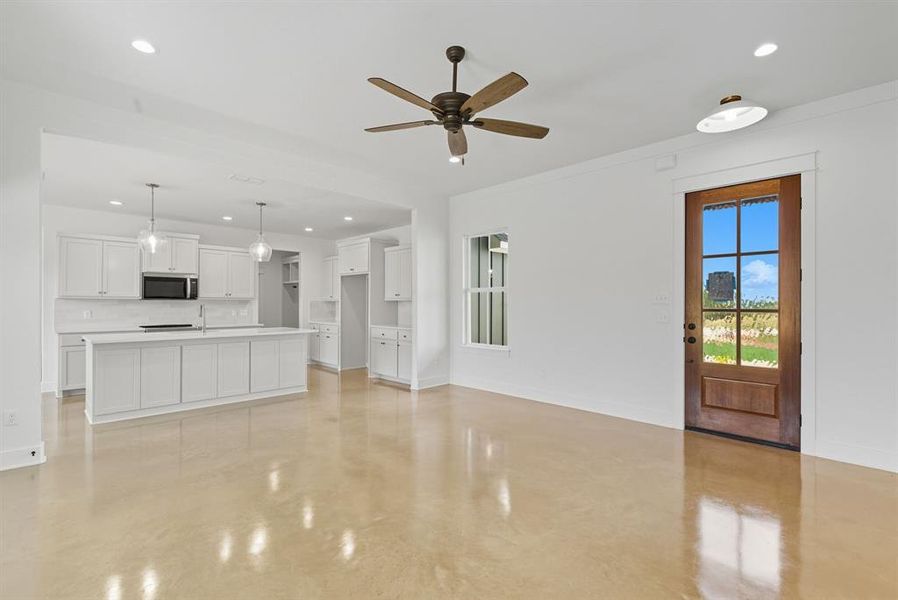 Unfurnished living room featuring finished concrete floors, recessed lighting, and ceiling fan