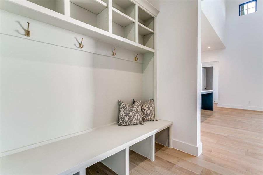 Mudroom featuring light wood-style flooring and baseboards