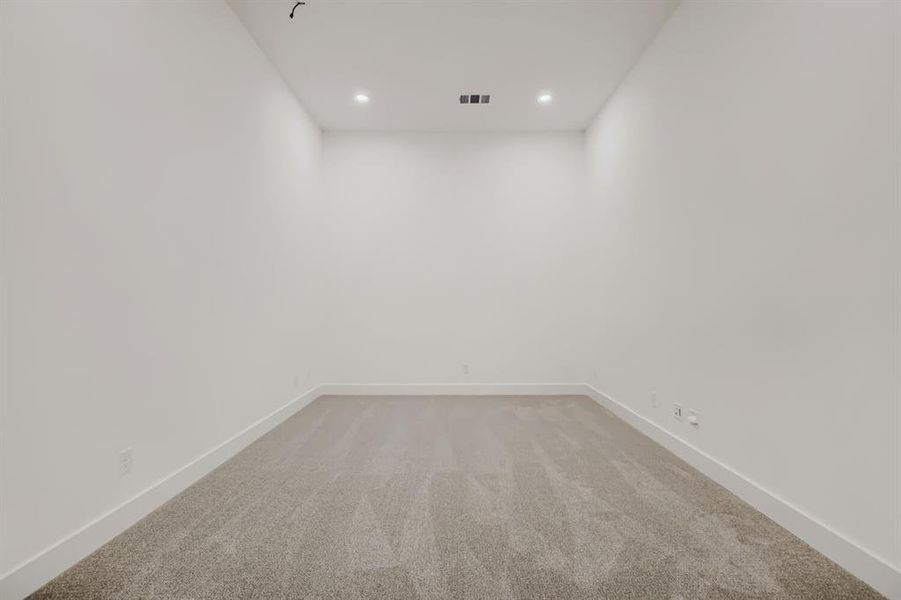 Carpeted room featuring recessed lighting, white walls, and white baseboards