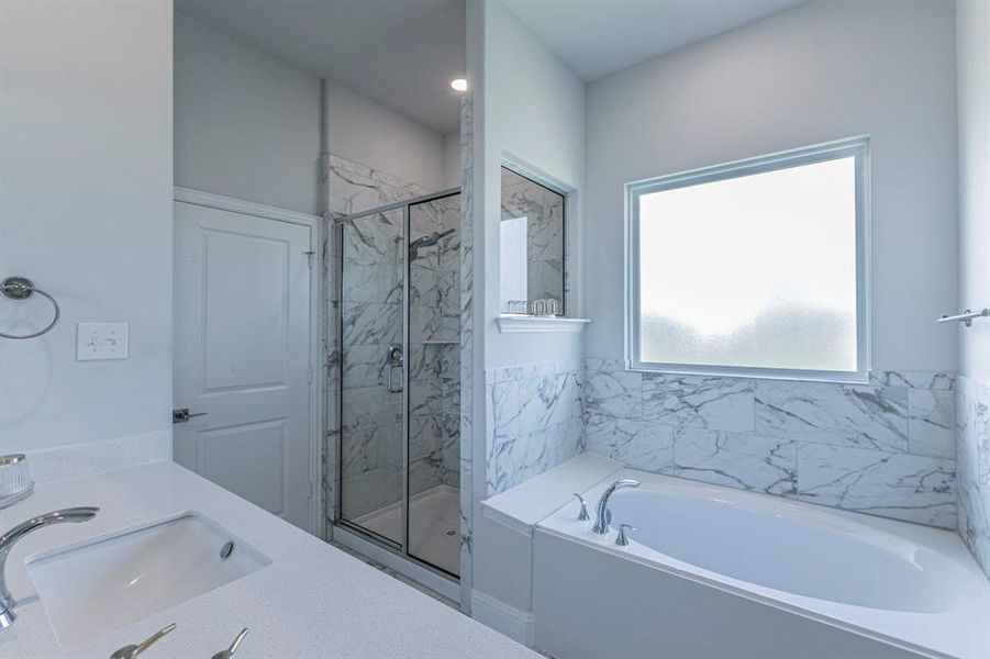 Bathroom with double vanity, a marble finish shower, and a garden tub Bathroom with double vanity, a marble finish shower, and a garden tub
