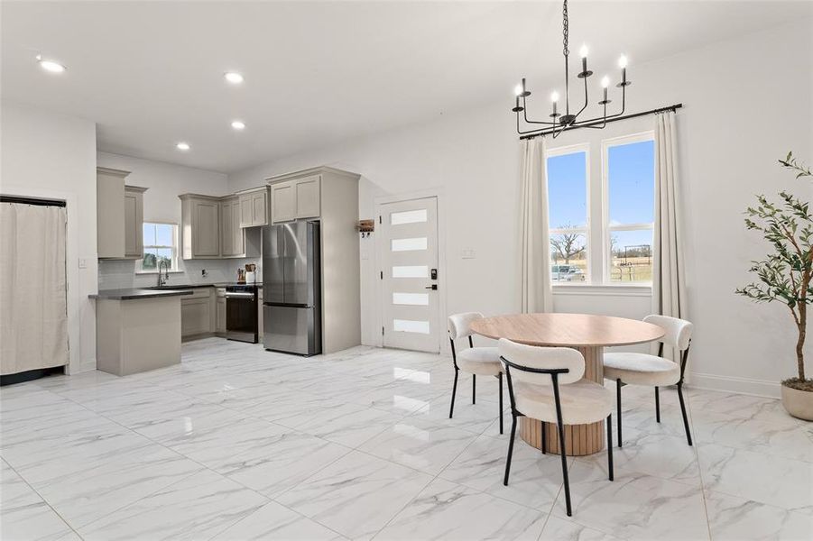 Kitchen featuring gray cabinets, freestanding refrigerator, pendant lighting, dark countertops, and recessed lighting