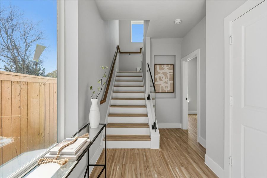 Bright, welcoming entry with natural light, warm wood flooring, and clean modern lines.Open staircase and thoughtful layout create an airy, sophisticated first impression.