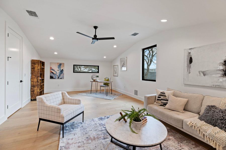 Living area featuring ceiling fan, lofted ceiling, light wood-style floors, recessed lighting, and baseboards