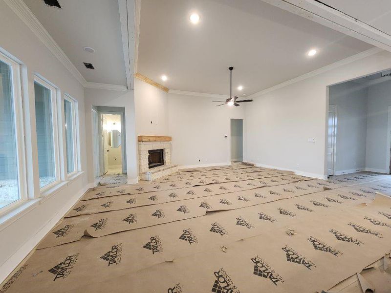Unfurnished living room with a fireplace, ceiling fan, ornamental molding, and recessed lighting