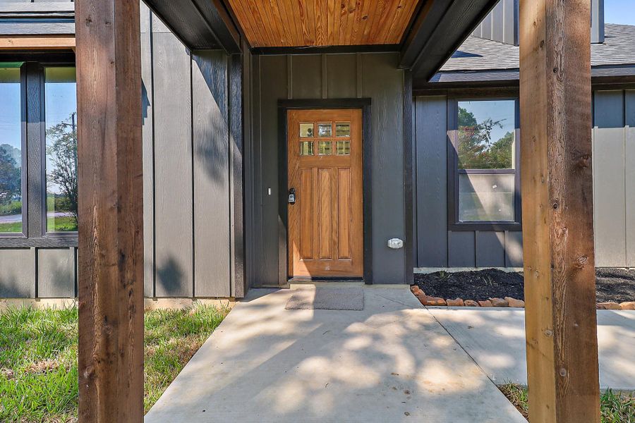 What a beautiful entrance to your home with stained beadboard matching the columns, front door and window corbels