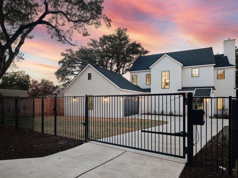 Gate at dusk with a fenced front yard Gate at dusk with a fenced front yard