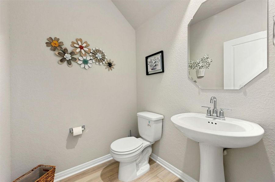 Guest Bathroom with wood-type flooring, toilet, and vaulted ceiling