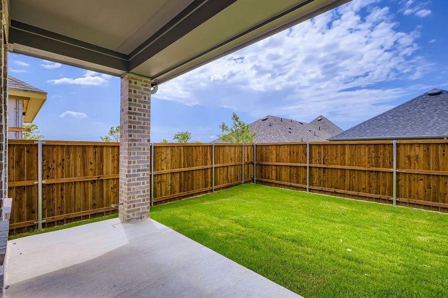 Fenced backyard with a patio