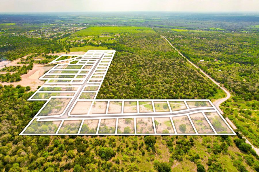 A new community with residential lots nestled among verdant trees and winding roads.