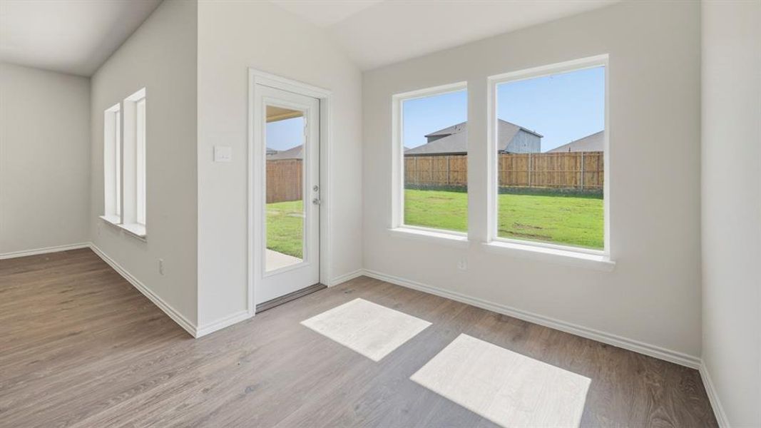 Entryway with wood finished floors and lofted ceiling