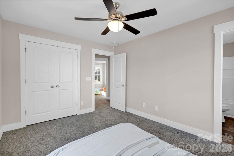 A peaceful, primary bedroom with soft natural light and room for a queen size furniture set.