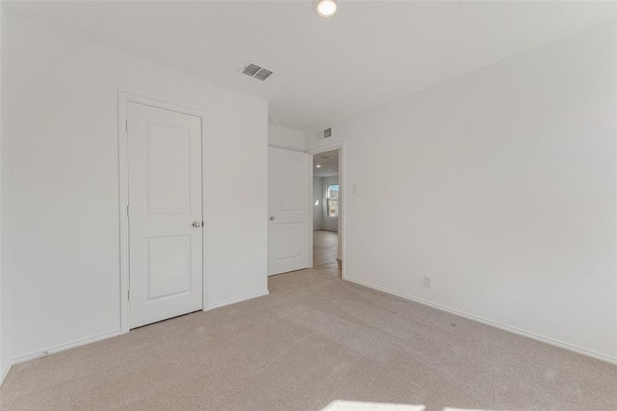 Unfurnished bedroom with light carpet