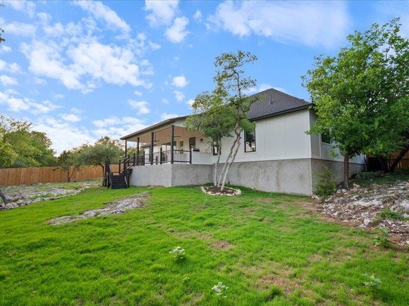 The property features a spacious yard with a lush lawn and mature trees