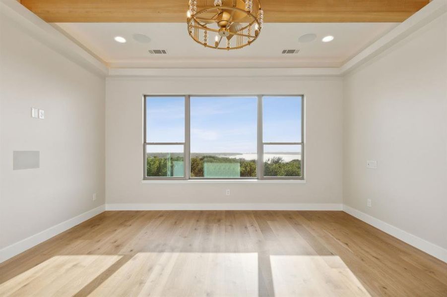 Unfurnished room featuring a chandelier, light wood finished floors, baseboards, and recessed lighting