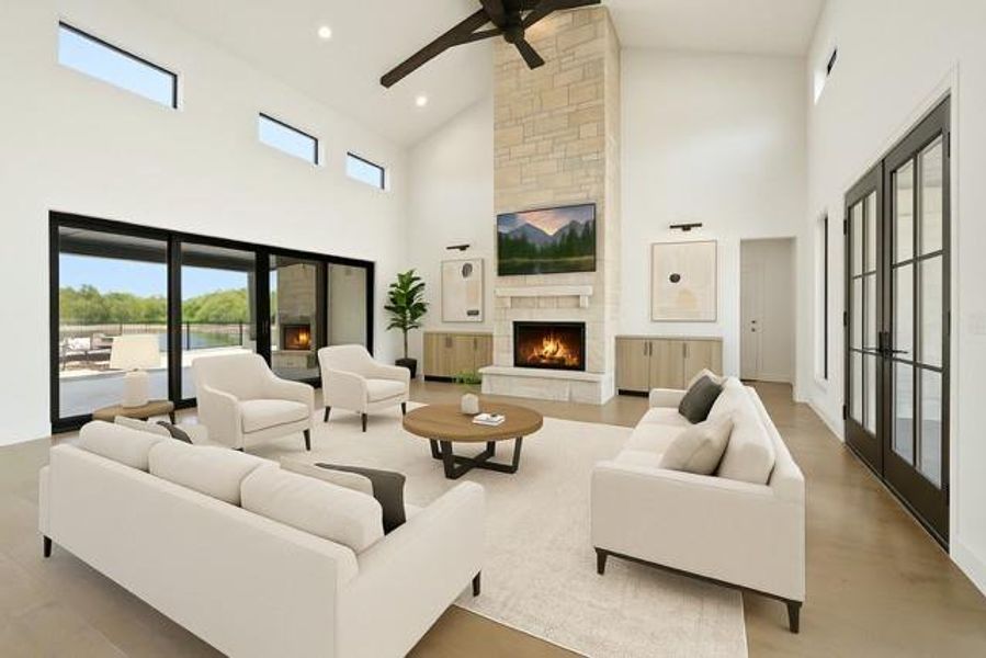 Living area featuring high vaulted ceiling, a stone fireplace, ceiling fan, healthy amount of natural light, and recessed lighting. Photo for example of possible furnishings.