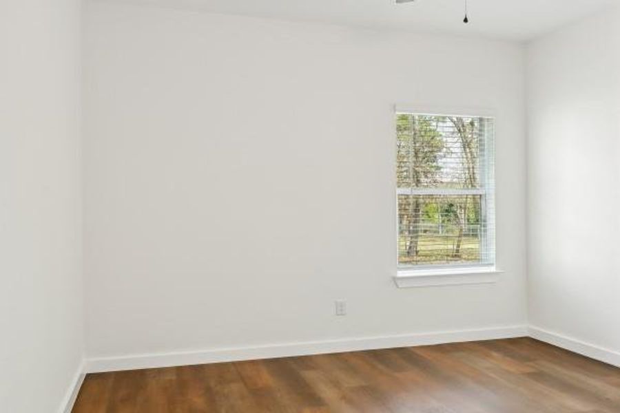 Cozy second bedroom with natural light and inviting vinyl plank floors. Cozy second bedroom with natural light and inviting vinyl plank floors.