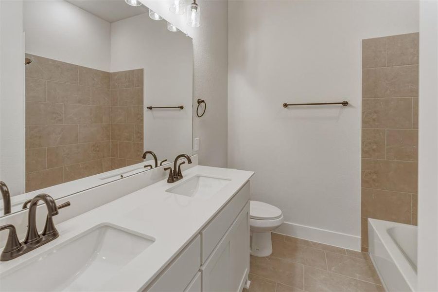 Double vanity with white countertop, integrated sinks, and bronze-finish faucets Double vanity with white countertop, integrated sinks, and bronze-finish faucets