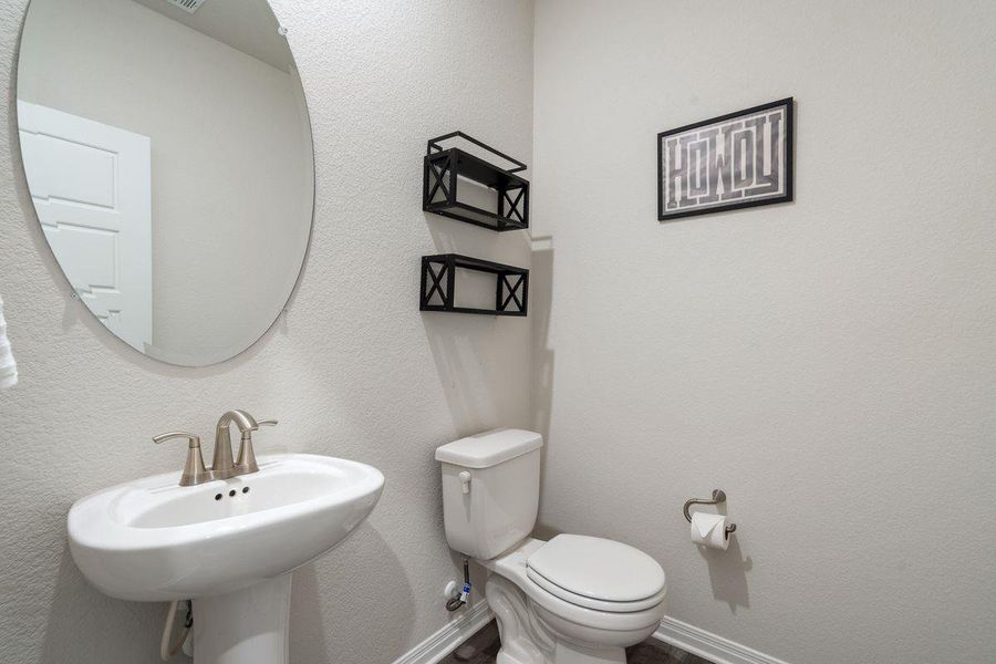 Stylish half bath downstairs with pedestal sink and modern finishes. Stylish half bath downstairs with pedestal sink and modern finishes.