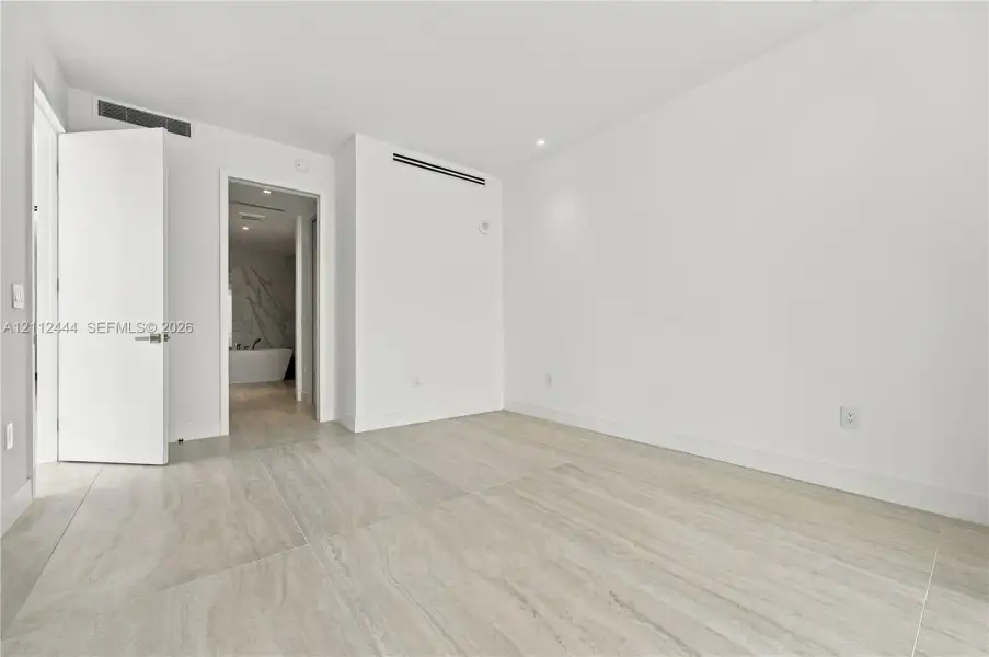 Large-format tile flooring, recessed ceiling lighting, and solid-core doors