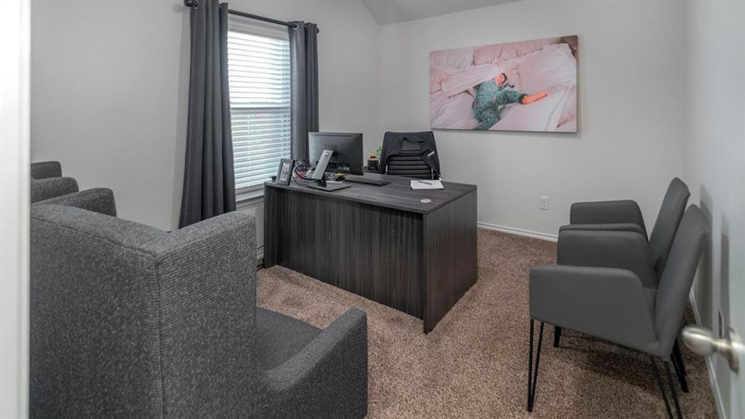 Office with carpet flooring and vaulted ceiling