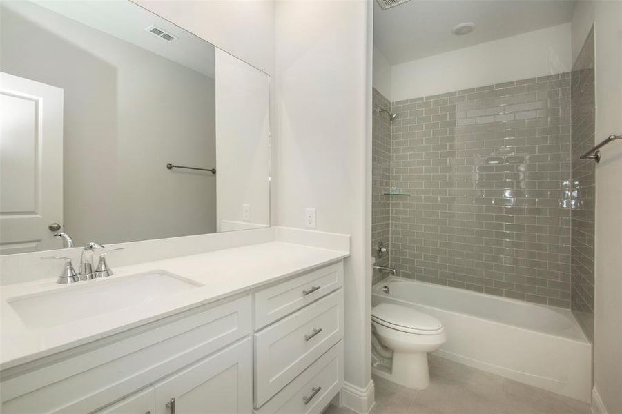Full bathroom with toilet, vanity, bathing tub / shower combination, and tile patterned flooring Full bathroom with toilet, vanity, bathing tub / shower combination, and tile patterned flooring