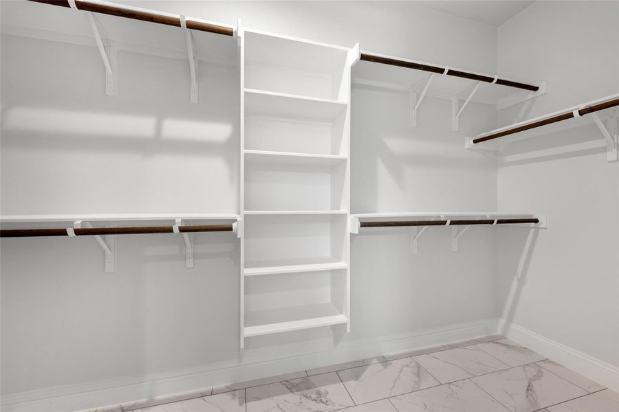 Walk in closet with light marble finish flooring