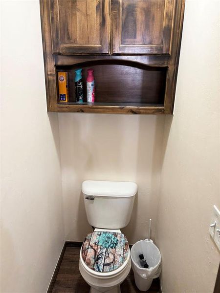 Bathroom with baseboards and dark wood-style flooring Bathroom with baseboards and dark wood-style flooring