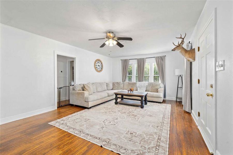 Living area with dark wood-style flooring and a ceiling fan Living area with dark wood-style flooring and a ceiling fan