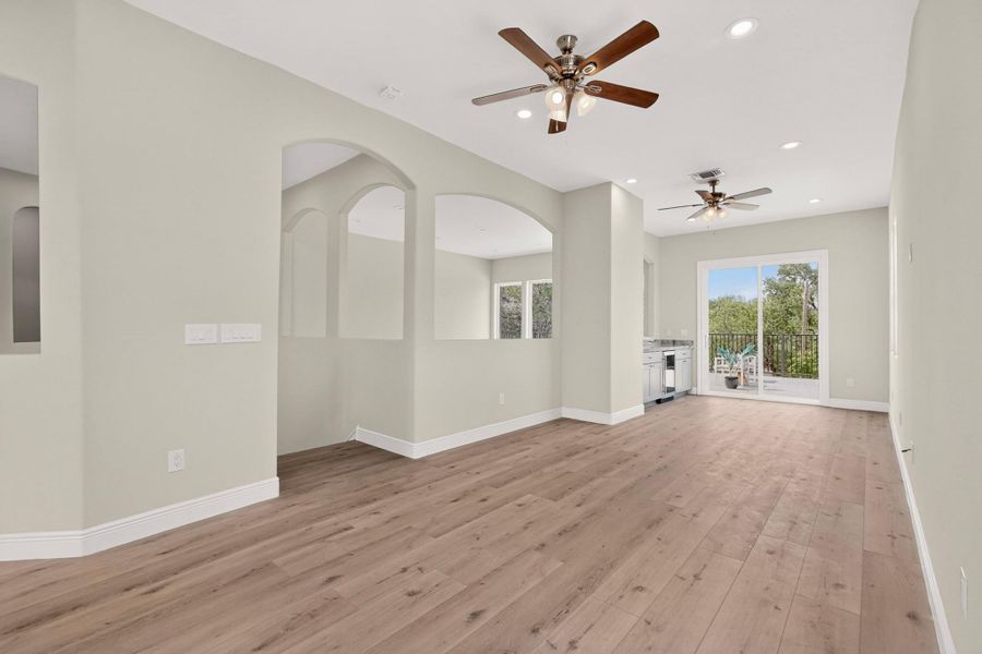 Arched cutouts and warm wood floors define this versatile open living space.