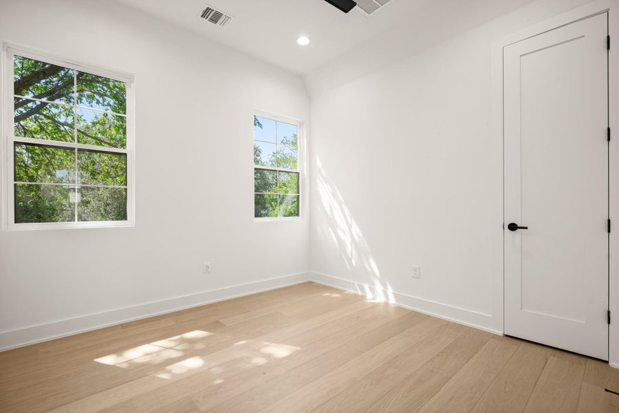 Hardwood floors and generous window lighting define this versatile, well-lit bedroom space. Hardwood floors and generous window lighting define this versatile, well-lit bedroom space.