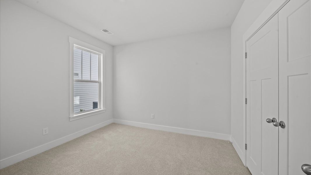 Inviting bedroom with tasteful finishes and large windows that create a fresh, open ambiance