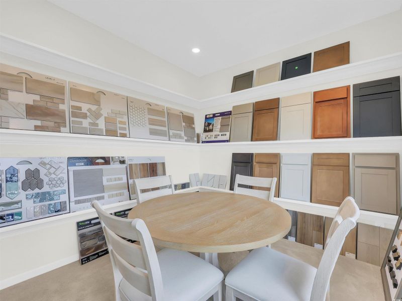 Dining space with light colored carpet and recessed lighting
