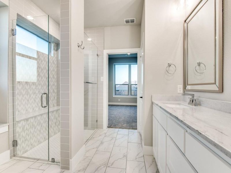 Bathroom with a wealth of natural light, visible vents, and marble finish floor Bathroom with a wealth of natural light, visible vents, and marble finish floor