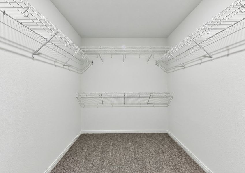 Walk-in closet featuring built-in wire shelving and hanging rods.