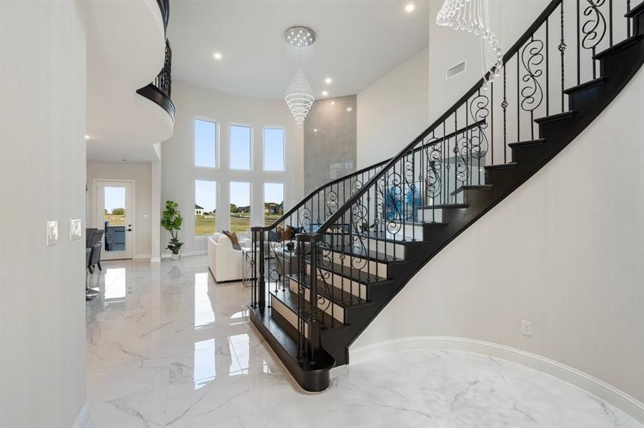 Stairs with a high ceiling and a notable chandelier