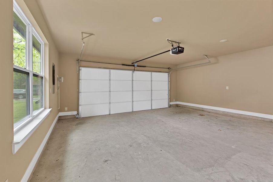 Garage with a garage door opener and baseboards Garage with a garage door opener and baseboards