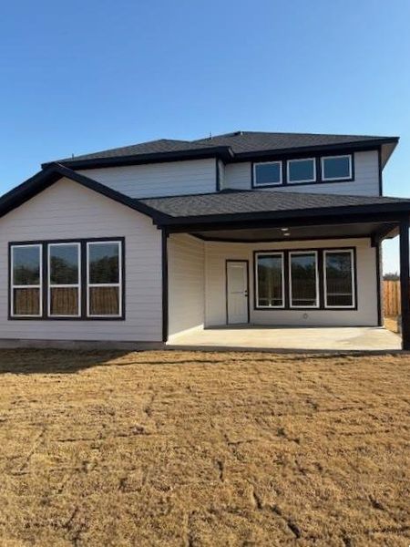 Back of property featuring a lawn and a patio area