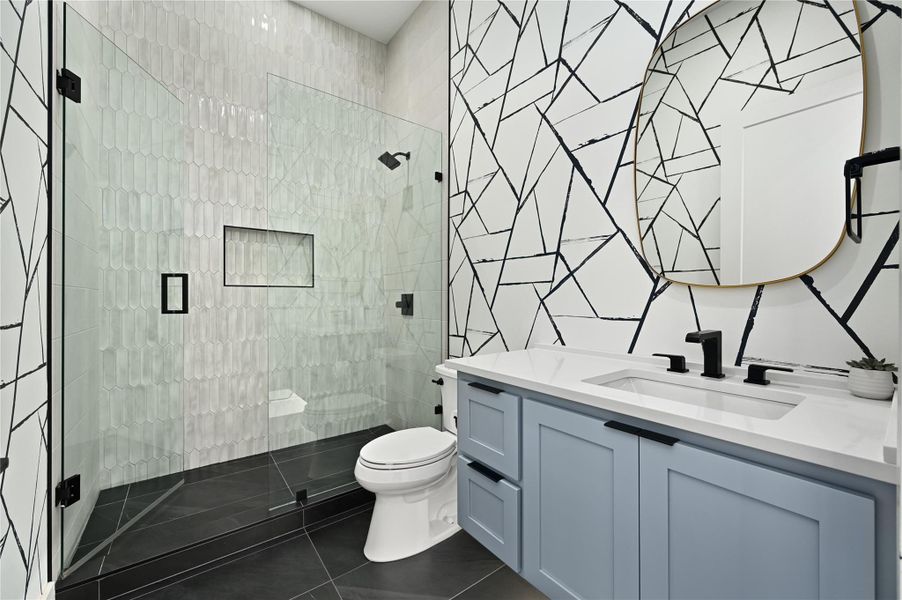 Full bath with toilet, tile walls, a shower stall, tile patterned flooring, and vanity
